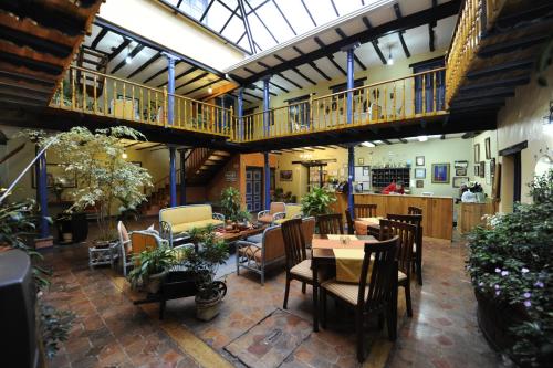 a restaurant with tables and chairs and a balcony at Hostal Posada del Angel in Cuenca