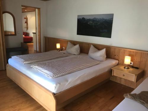 a bedroom with a large bed with two lamps on tables at Haus Petra in Oberjoch