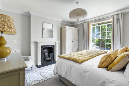 a bedroom with a large bed and a fireplace at Poplar Cottage, Budleigh Salterton in Budleigh Salterton