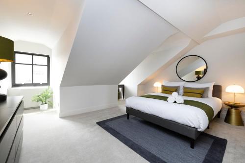 a bedroom with a large bed and a mirror at JOIVY Luxury Flat near Edinburgh Castle in Edinburgh