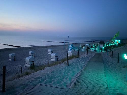 a beach at night with chairs and umbrellas at Ferienwohnung Dünenhopser in Rostock