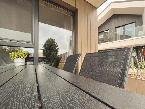 a black table and chairs on a balcony at Jūros 40 in Šventoji