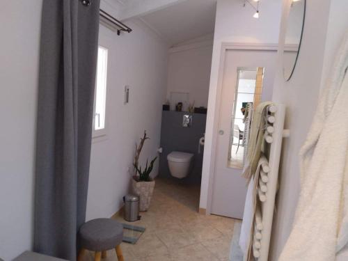 ein Bad mit einem WC, einem Waschbecken und einer Tür in der Unterkunft La Lézardière in Paradou
