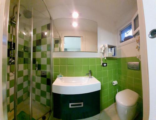 un bagno piastrellato verde con lavandino e doccia di Bed& Breakfast G&G a Porto Garibaldi