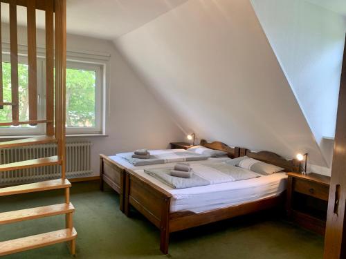 um quarto com uma cama grande num sótão em Ferienhaus DHH "Unsere Reetdachbude" em Sankt Peter-Ording