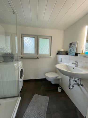 a white bathroom with a sink and a toilet at Casa Melina in Bernsdorf