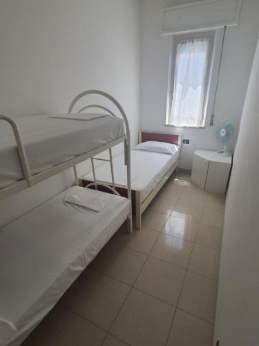 a room with two bunk beds and a window at Appartamento estivo seconda fila dal mare in Grottammare