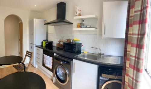 a kitchen with a sink and a washing machine at Norwood Guesthouse-Loch Lomond in Balloch
