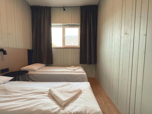 a hotel room with two beds and a window at Jūros 40 in Šventoji