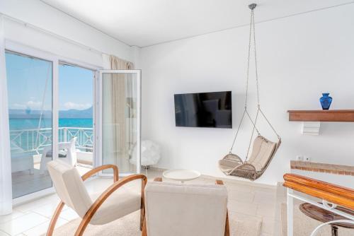 a white living room with a view of the ocean at COSTA VASIA Seaside Suites and Apartments in Vrahati