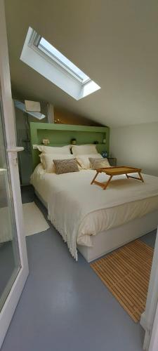 a bedroom with a large bed with a skylight at Cosy Corner in Jalhay