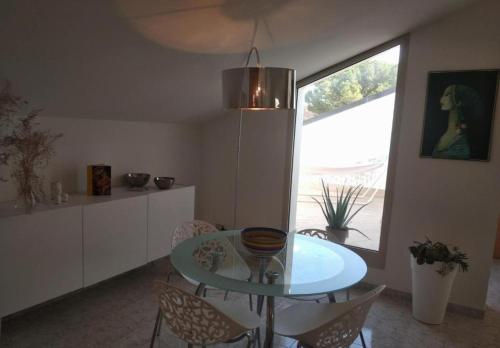 une salle à manger avec une table et des chaises en verre dans l'établissement Casa Vacanza Le Nid d'Assise, à Bastia Umbra
