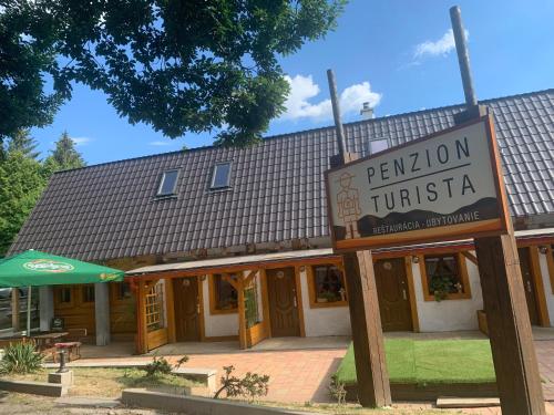a building with a sign in front of it at Penzión Turista in Banská Štiavnica
