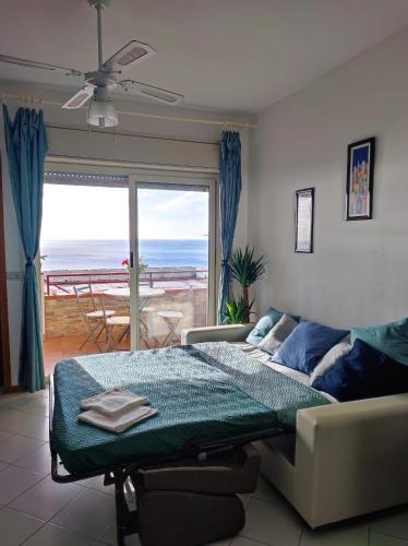 a bedroom with a bed and a view of the ocean at Bellavista apartment Letojanni in Letojanni