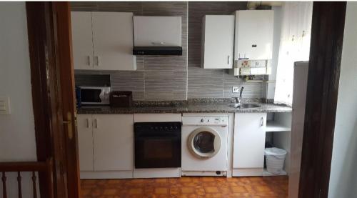 a kitchen with white cabinets and a washing machine at Piso casco antiguo in Vitoria-Gasteiz
