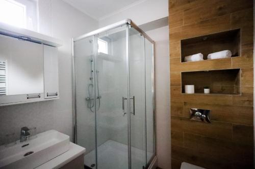 a bathroom with a glass shower and a sink at Domaćin Komšijska Gostiona in Zrenjanin