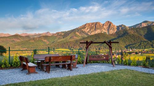 two benches and a table with a view of mountains at Wierchowa Chata in Kościelisko