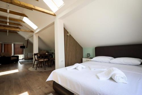 a bedroom with a white bed with white towels on it at Domaćin Komšijska Gostiona in Zrenjanin