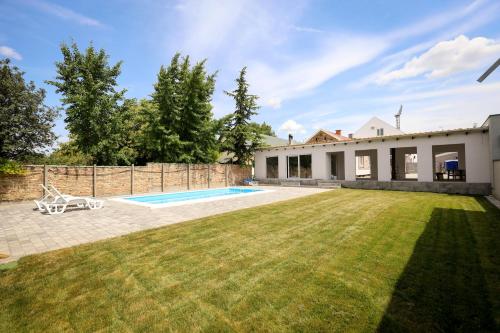 a backyard of a house with a swimming pool at Domaćin Komšijska Gostiona in Zrenjanin