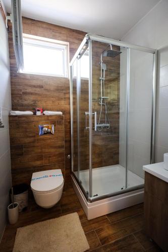 a bathroom with a glass shower and a toilet at Domaćin Komšijska Gostiona in Zrenjanin