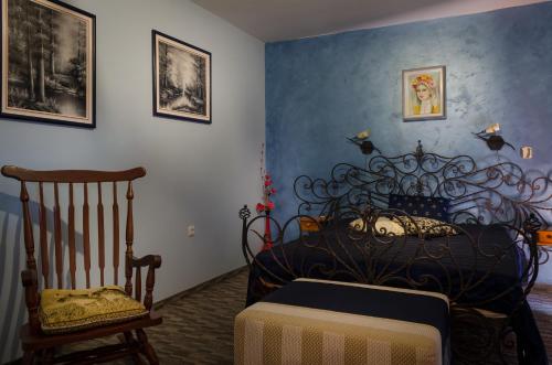 a bedroom with a black bed and a chair at Kalypso Hotel in Primorsko