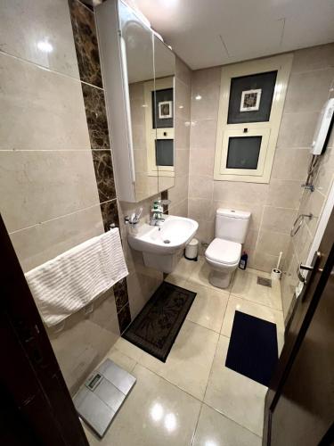 a bathroom with a white toilet and a sink at Elegant duplex with pool frontAUC in Cairo