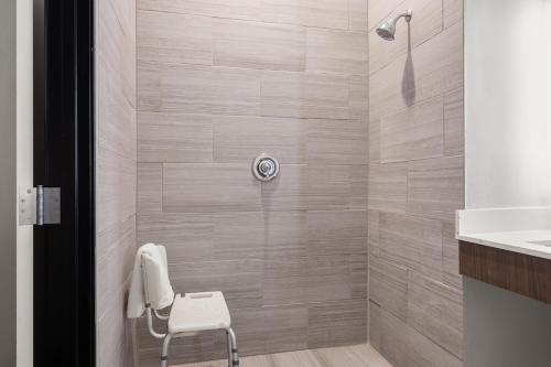 a shower with a white chair in a bathroom at Holiday Inn Express & Suites Graham, an IHG Hotel in Graham