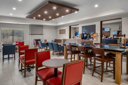 een restaurant met tafels en stoelen en een bar bij Holiday Inn Express & Suites Graham by IHG in Graham
