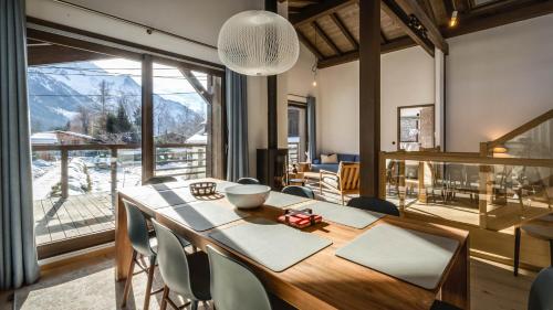 une salle à manger avec une table et des chaises et une grande fenêtre dans l'établissement Chalet Etoile, à Chamonix-Mont-Blanc