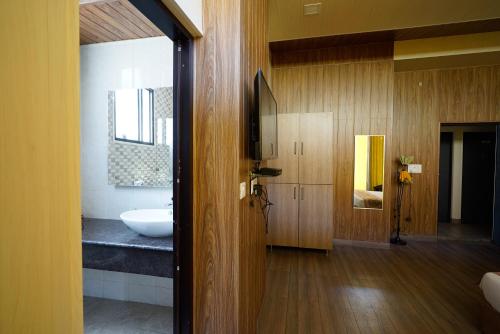 德拉敦Haut Monde Hill Stream Resort and Spa的客房内设有带水槽和浴缸的浴室