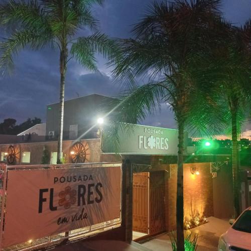 a street with palm trees in front of a building at Pousada Flores em Vida in Olímpia