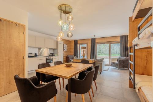 a kitchen and dining room with a wooden table and chairs at Les Terrasses de la Vanoise in Champagny-en-Vanoise