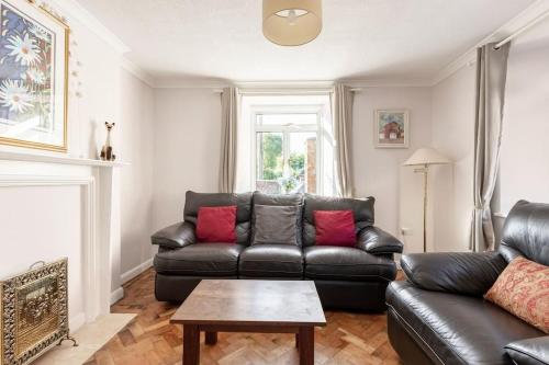 a living room with a black leather couch and a table at The Old Gasworks in Milverton