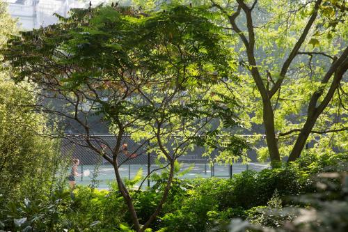a man is walking in a park with trees at Jumeirah Carlton Tower London in London