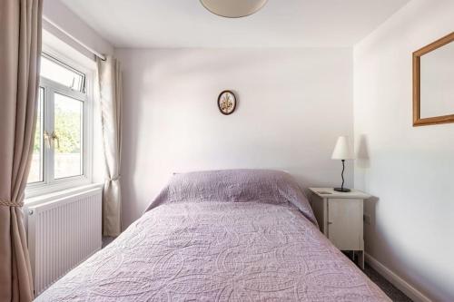 a white bedroom with a bed and a window at The Old Gasworks in Milverton