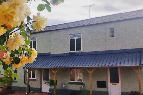 a house with yellow flowers in front of it at The Old Gasworks in Milverton