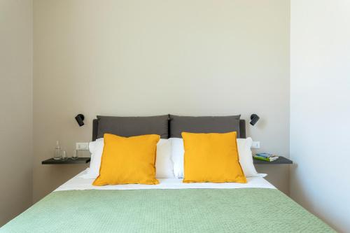 a bedroom with a bed with yellow pillows at Mori's Rooms in Palermo