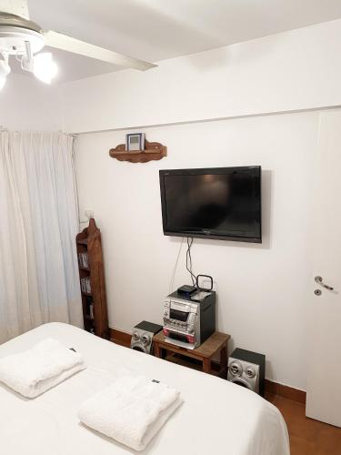 1 dormitorio con 1 cama y TV en la pared en Departamento con estilo salteño en Salta