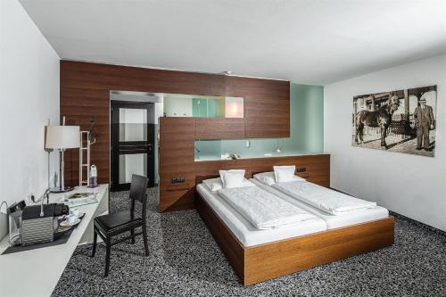 a bedroom with a large bed and a desk and a chair at Hotel Rauter in Matrei in Osttirol