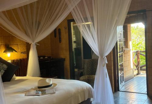 a bedroom with a bed with a hat on it at Zwahili Private Game Lodge & Spa in Modimolle