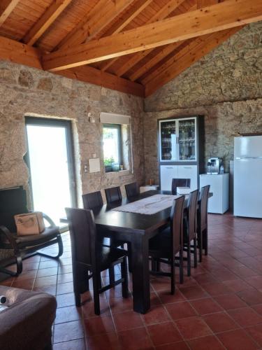 a dining room with a table and chairs and a kitchen at Florindo - Lafões Guest House in Oliveira de Frades