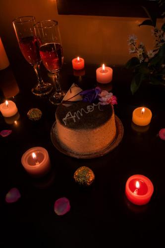 a table with a cake and candles and wine glasses at Hotel Luxor Pereira in Pereira