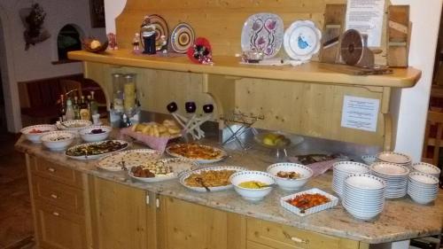 un buffet con muchos platos de comida en una barra en Hotel Ciamol en Mazzin