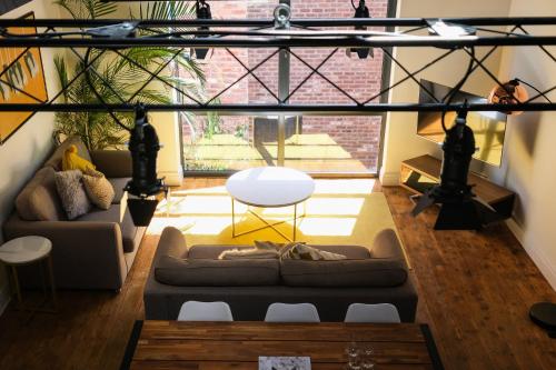 a living room with a couch and a table at The Eden Warehouse - Gold Apartment, sleeps 5 in Southport