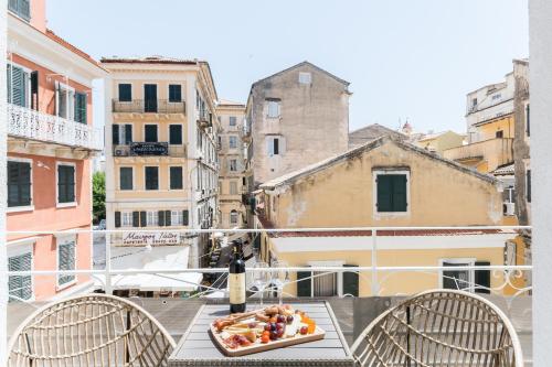 a plate of food on a table on a balcony at Koukounara Apartments Collection by Konnect, Old Corfu Town in Corfu