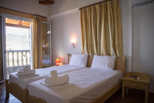 1 dormitorio con 1 cama grande y toallas. en Amalia Apartments, en Stoupa