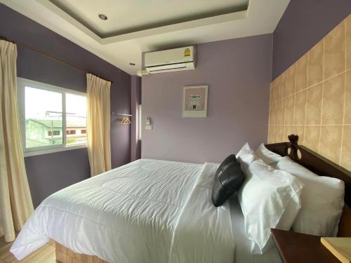 a bedroom with a white bed and a window at Saming Chiang Dao Guest House in Chiang Dao