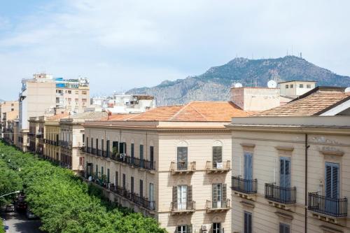 a group of buildings with a mountain in the background at Mori's Rooms in Palermo