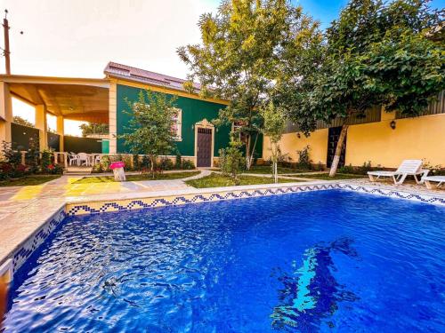 a swimming pool in front of a house at Qafqaz Mini Villa in Gabala