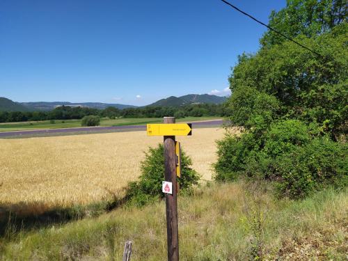 a yellow sign on a pole in the middle of a field at les mésanges in Chaffaut-Lagremuse